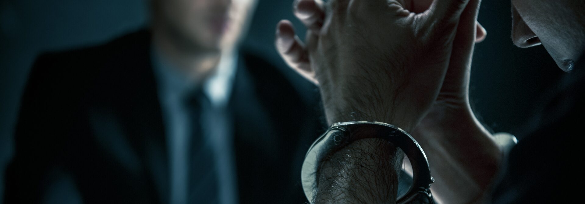 man with head in hands with handcuffs on