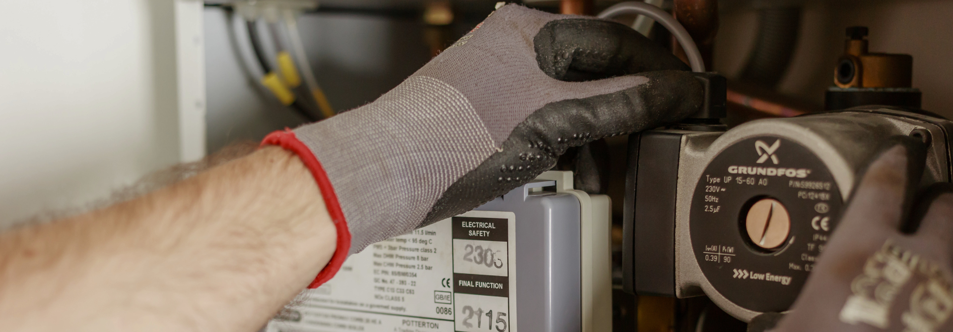 Hands in gloves fixing a boiler