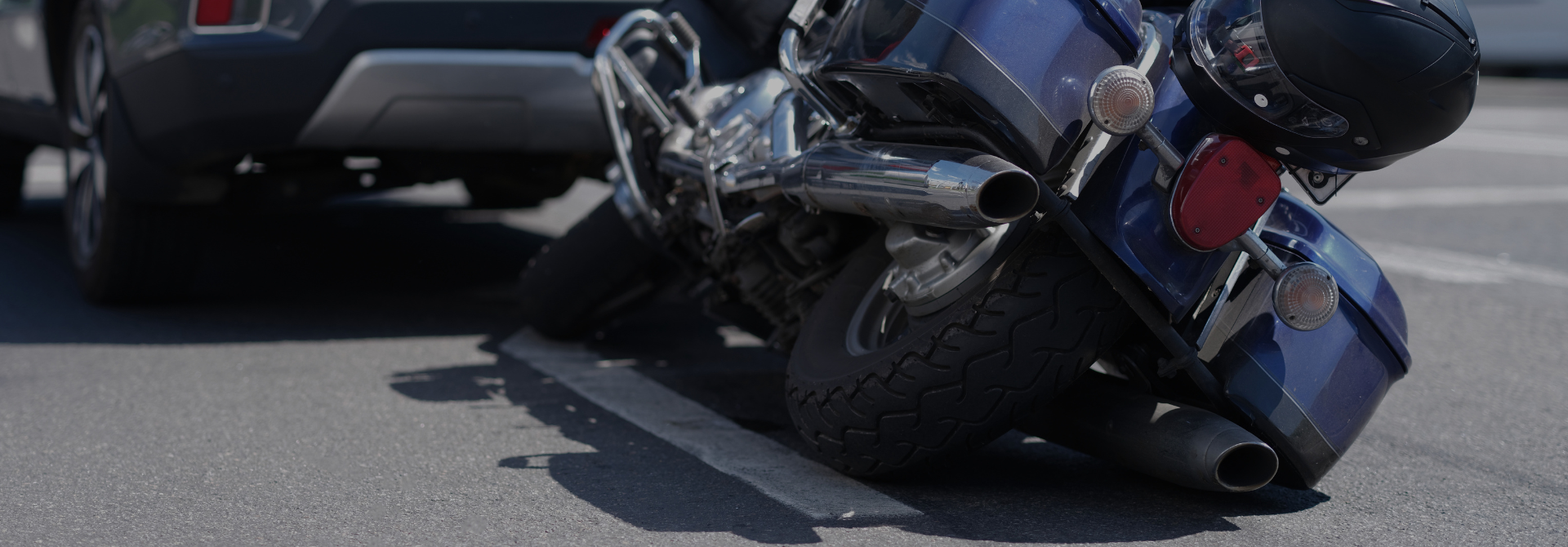 motorbike on its side behind a car