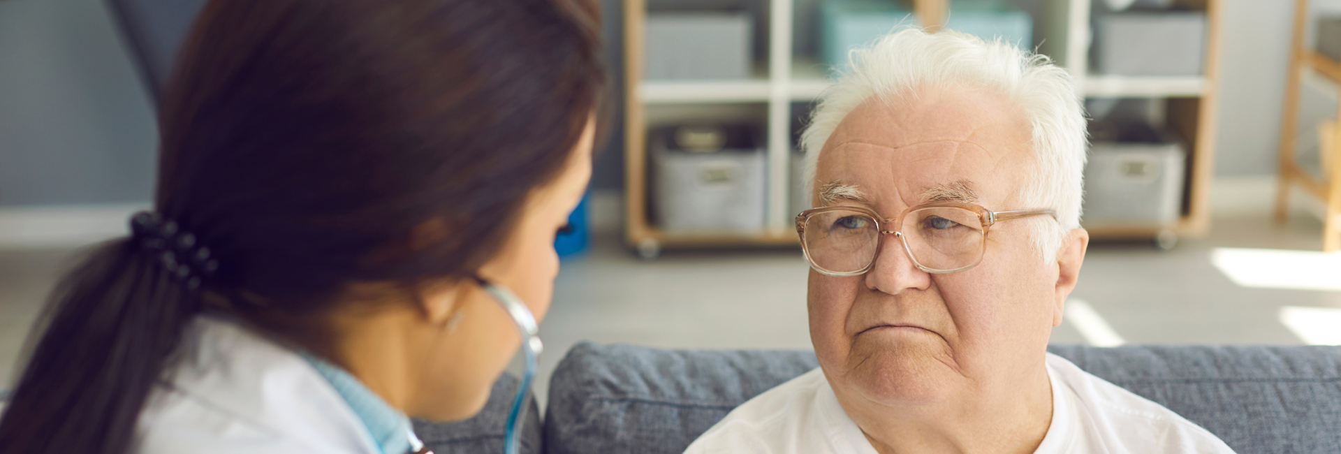 Older man having his chest listened to by a female doctor